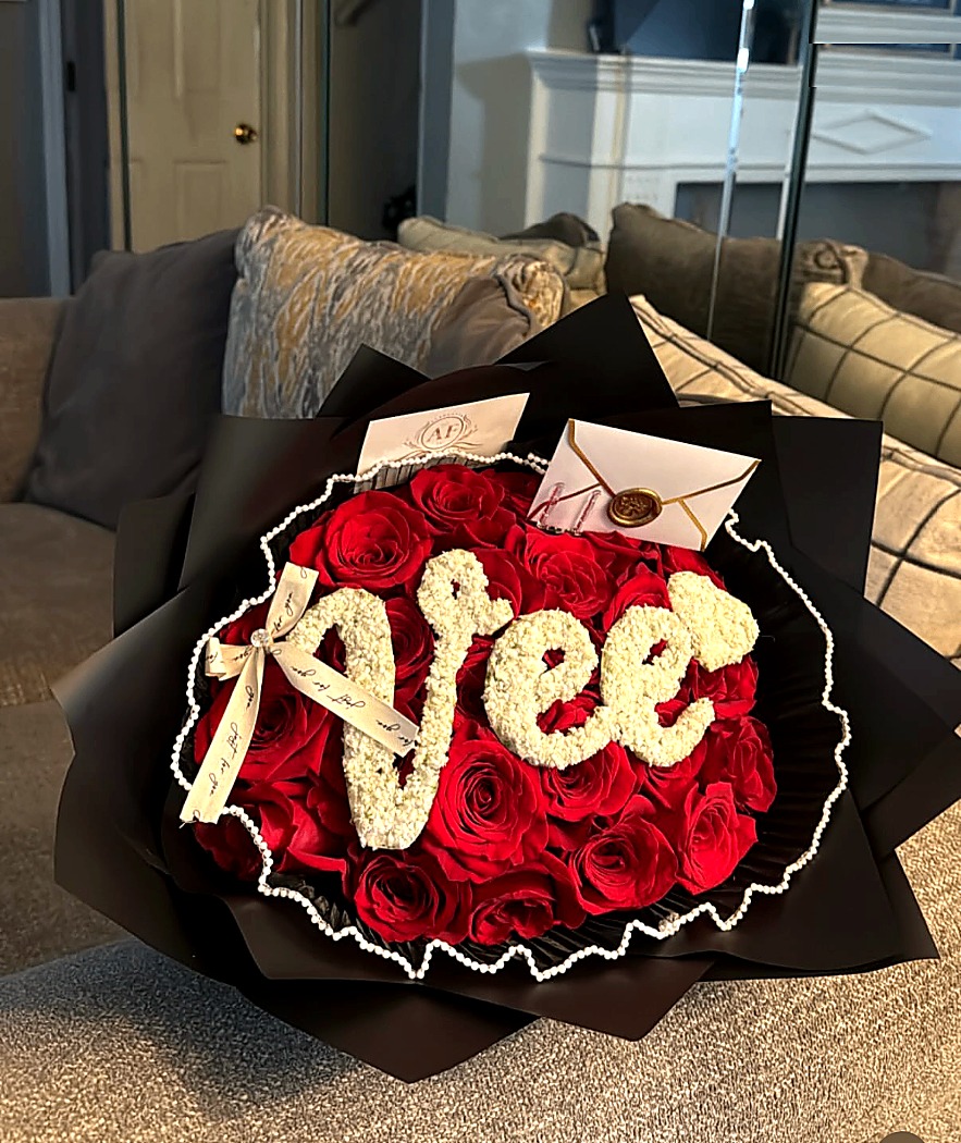 Luxury red rose bouquet with custom floral lettering, styled for a special gifting moment.