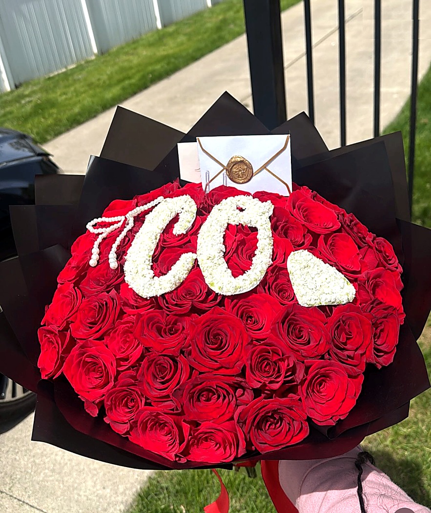 Deep red luxury rose bouquet with custom floral lettering.